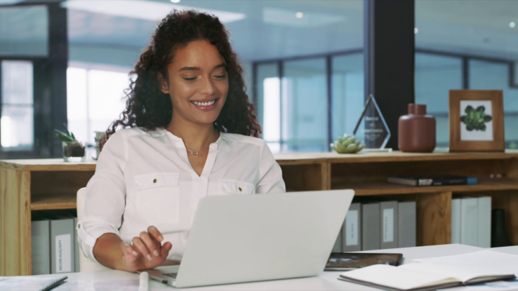 Woman sitting back at desk, happy with her work